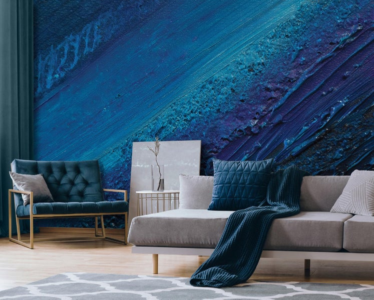 Wohnzimmer mit blauem Sofa, Sessel und gemusterter Tapete