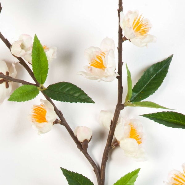 Künstlicher Kirschblütenzweig mit weißen Blüten und grünen Blättern.
