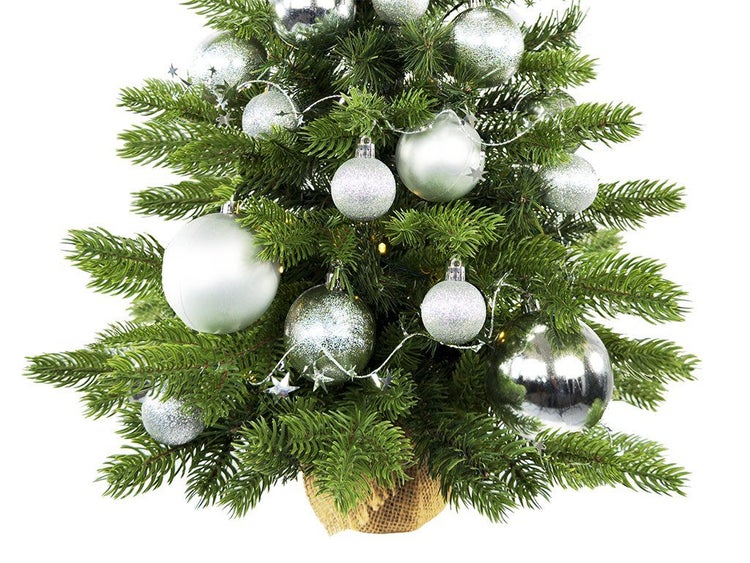 Künstlicher Weihnachtsbaum mit LED Beleuchtung und silberner Dekoration im Jutesack.