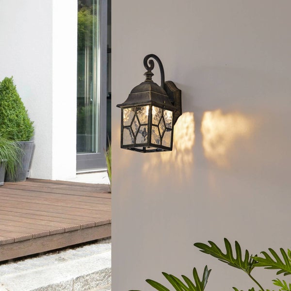 Außenwandleuchte mit Glaseinsätzen und dekorativem Design an einer Fassade.