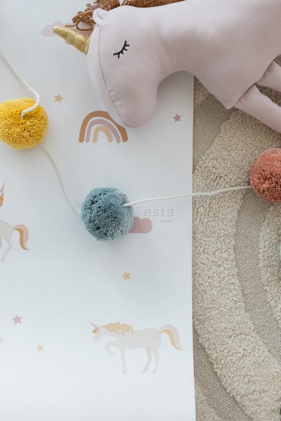 Dekoratives Kinderzimmer mit Einhorn-Motiv, Pompon-Girlande und Plüscheinhorn