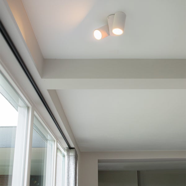 Zwei weiße Deckenstrahler in einem hellen Raum mit Fenster