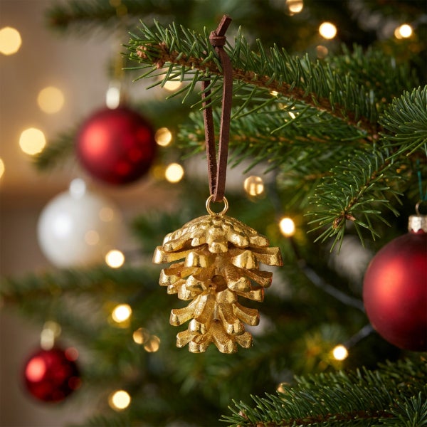 Weihnachtsbaumanhänger in Form eines Tannenzapfens mit Lederband am Tannenbaum hängend