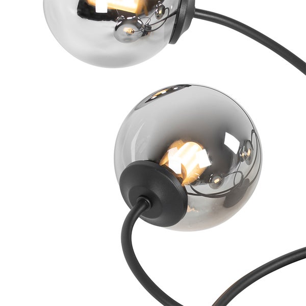 Nahaufnahme einer Lampe mit runden, getönten Glasschirmen und schwarzem Gestell