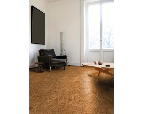 Moderner, heller Wohnraum mit strukturiertem Korkfußboden, Sessel und großem Fenster.