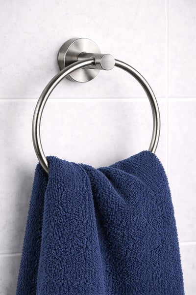 Wandmontierter Handtuchring aus gebürstetem Metall mit einem blauen Handtuch an einer Fliesenwand.