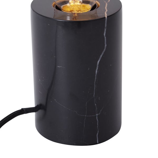 Zylindrische Tischleuchte aus schwarzem Marmor mit weißer Maserung und sichtbarem Leuchtmittel.
