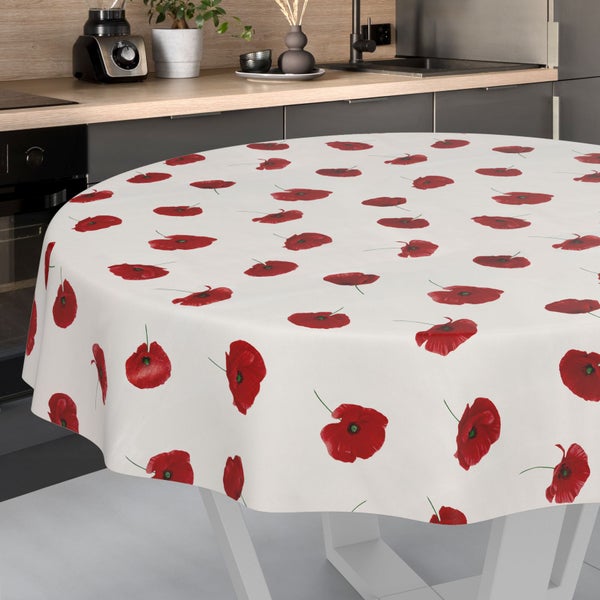 Rundes Wachstuch mit Mohnblumen-Muster auf einem Küchentisch in einer hellen, modernen Küche mit Arbeitsplatte aus Holz.