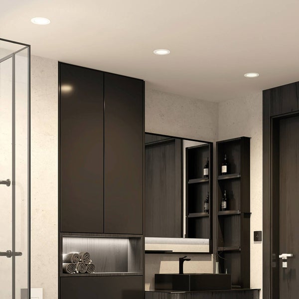 Drei runde LED-Einbaustrahler in einer Badezimmerdecke über modernen Badmöbeln, einem Waschbecken und einer Glasduschwand.