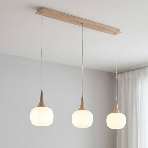 Dreiflammige Pendelleuchte mit Holzbalken und runden weißen Glasschirmen in einem hellen modernen Raum.