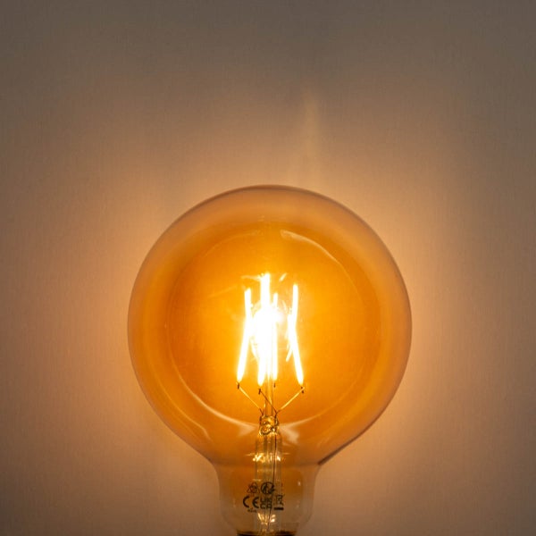 Leuchtende LED-Filament-Globelampe mit bernsteinfarbenem Glas.