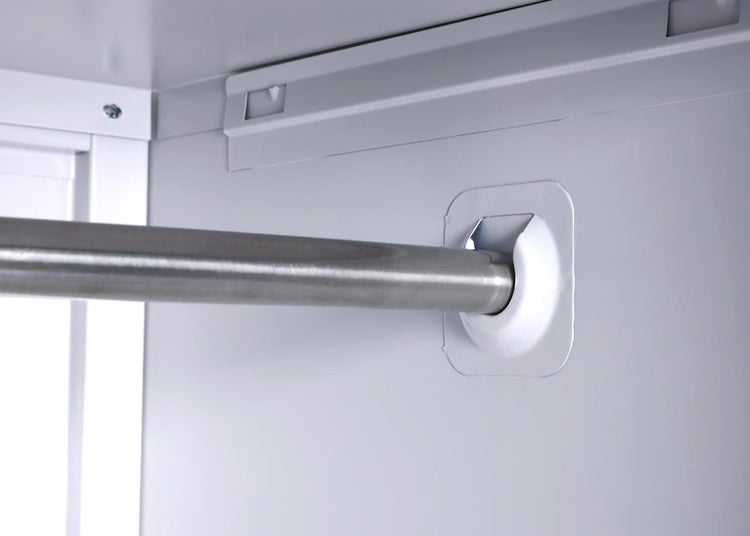 Detailansicht einer Kleiderstange in einem Schrank.