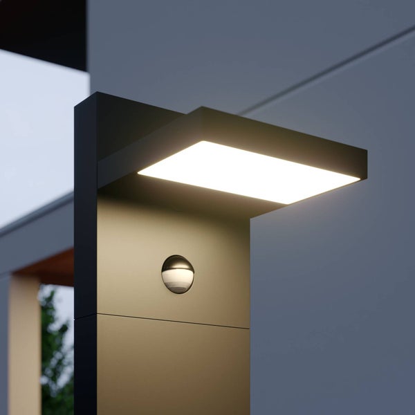 Moderne anthrazitfarbene Außen-LED-Wandleuchte mit integriertem Bewegungsmelder, die nach unten strahlt.
