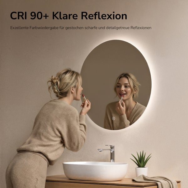 Eine Frau schminkt sich vor einem runden LED Badspiegel mit hoher Farbwiedergabe über einem weißen Keramikwaschbecken in einem hellen Badezimmer.