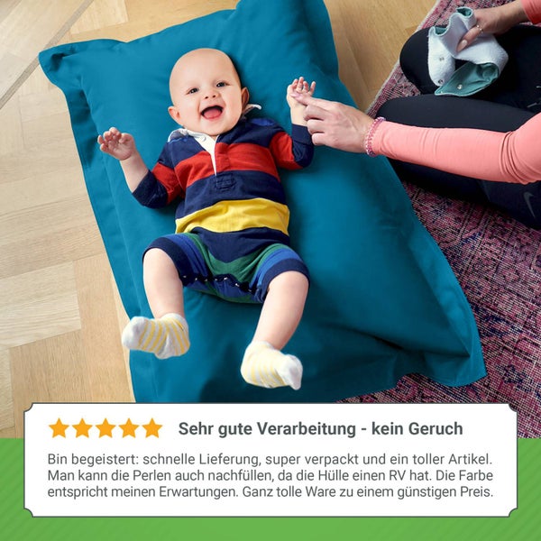 Fröhliches Baby auf blauem Sitzsack
