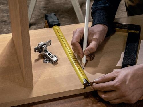 Holzbearbeitungsszene mit Bandmaß, Winkel, Bleistift und Scharnier