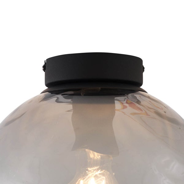 Nahaufnahme einer Deckenleuchte mit Glasschirm und Metallfassung