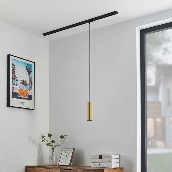 Minimalistische, goldfarbene zylindrische Pendelleuchte an einem schwarzen Schienensystem in einem hellen, modernen Raum.