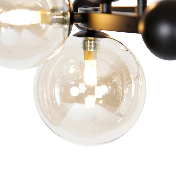 Detailaufnahme einer Lampe mit runden Glasschirmen und schwarzem Gestell