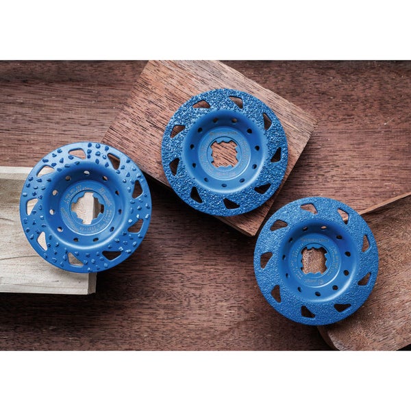 Drei blaue Schleifscheiben für Holzbearbeitung auf Holzgrund