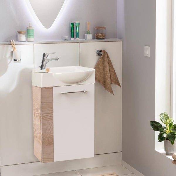 Modernes Badezimmer mit Waschbeckenunterschrank, Handtuch und Zimmerpflanze für eine helle und freundliche Atmosphäre.