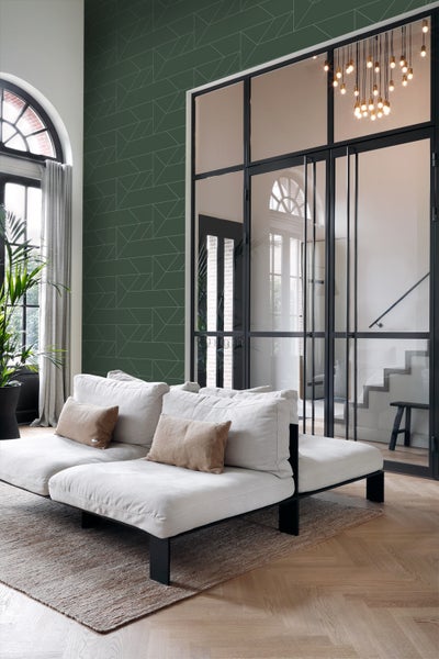 Wohnzimmer mit Sofa, Teppich und geometrischer Tapete