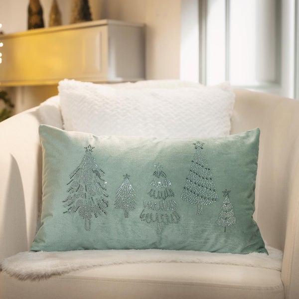 Weihnachtskissen mit Tannenbaum Motiv aus Schmucksteinen auf einem Sessel mit flauschigem Kissen im Hintergrund