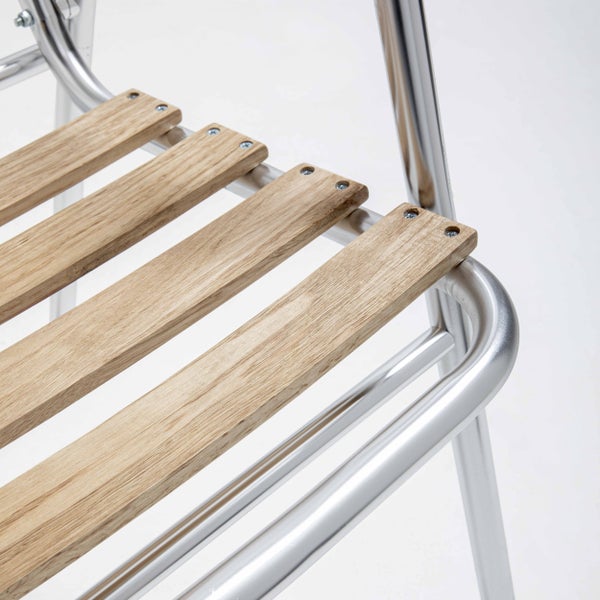 Detailansicht einer Sitzfläche mit Holzlatten und einem silbernen Metallrahmen.
