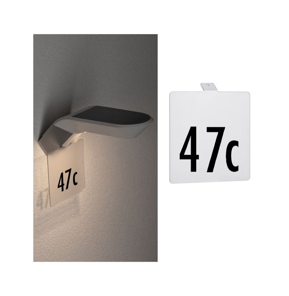 Solar Hausnummernleuchte mit Sensor montiert an einer Wand und ein separates Hausnummernschild mit der Beschriftung 47c.