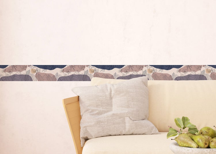 Tapetenbordüre mit floralem und abstraktem Landschaftsdesign an einer Wand in einem Wohnzimmer mit Sofa und Kissen.