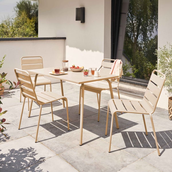 Beige Gartenmöbel-Set aus Metall auf einer hellen Terrasse, bestehend aus einem rechteckigen Tisch und vier Stapelstühlen mit Lattendesign.