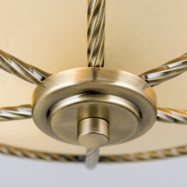 Detailansicht einer Deckenleuchte mit gedrehten Metallstreben und einer runden Halterung in Antikoptik.