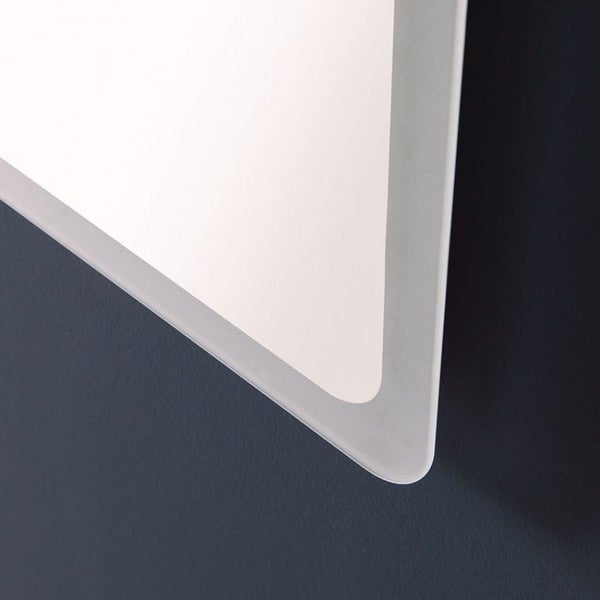 Detailansicht der abgerundeten Ecke eines Badezimmerspiegels mit satiniertem Rand.