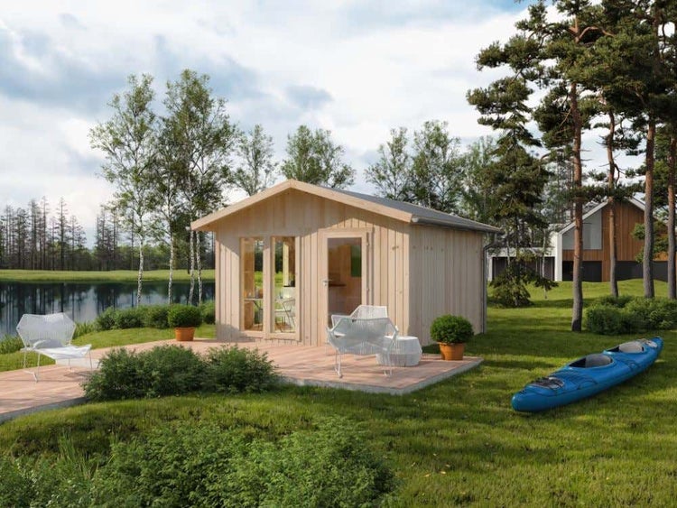 Hell gestaltetes Gartenhaus aus Holz mit Satteldach auf einer Holzterrasse an einem See mit Bäumen und einem blauen Kajak.