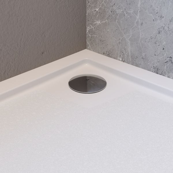 Weiße Duschwanne mit strukturierter Oberfläche und rundem Abflussdeckel in einer Ecke.