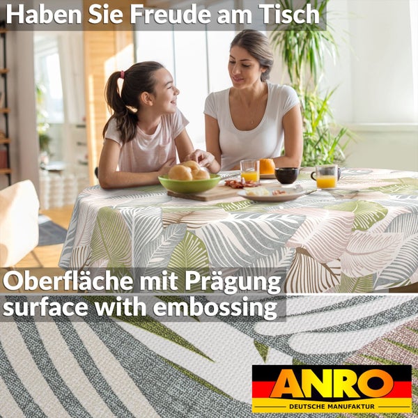 Rundes Tischtuch mit tropischem Blattmuster und geprägter Oberfläche auf einem gedeckten Tisch in hellem Ambiente mit ANRO Logo.