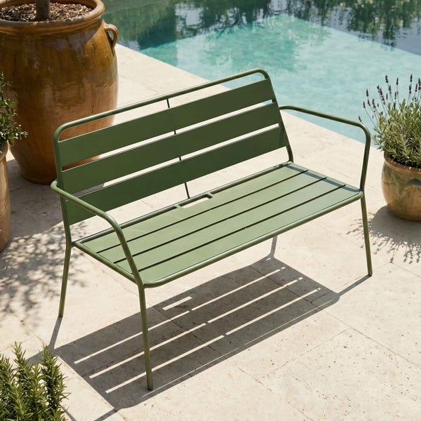 Moderne Gartenbank aus Metall mit horizontalen Latten auf einer Steinterrasse neben einem Swimmingpool, umgeben von Pflanztöpfen.