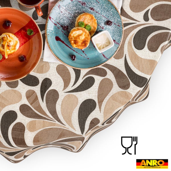 Tischdecke mit Tropfenmuster in Braun und Beige auf einem Frühstückstisch. Lebensmittelecht Symbol und ANRO Deutsche Manufaktur Logo.
