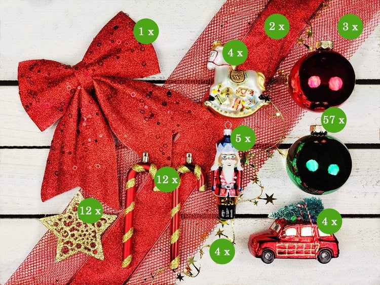 Weihnachtsbaumschmuck Set mit Dekoschleife, Baumkugeln, Schaukelpferd, Nussknacker, Zuckerstangen, Sternen und Auto auf Holzhintergrund.