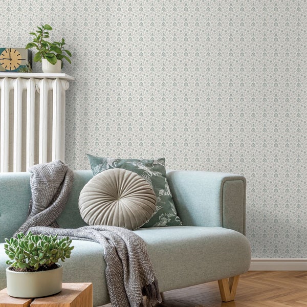 Wohnzimmer mit Couch und floral gemusterter Tapete