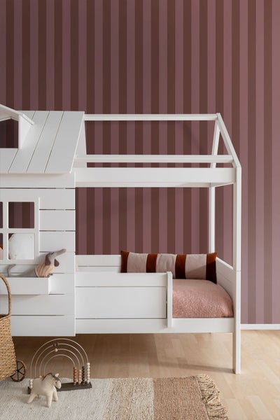 Kinderzimmer mit gestreifter Vliestapete in Mauve, weißem Hausbett und hellem Holzfußboden.