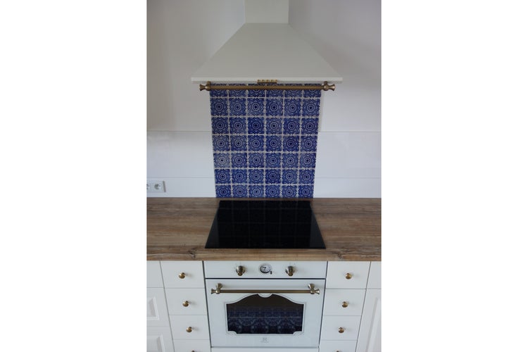 Küchenszene mit Dunstabzugshaube, Kochfeld und Backofen in einer hellen, organisierten Anordnung.