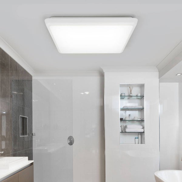 Große, quadratische, weiße LED-Deckenleuchte in einem hellen, modernen Badezimmer mit Glasdusche und grauen Fliesen.