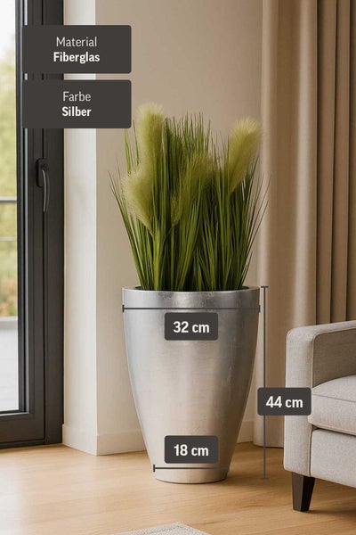 Silberner Pflanzkübel aus Fiberglas mit Kunstpflanze in einem hellen Wohnzimmer. Höhe 44 Zentimeter, Breite oben 32 Zentimeter, Breite unten 18 Zentimeter.