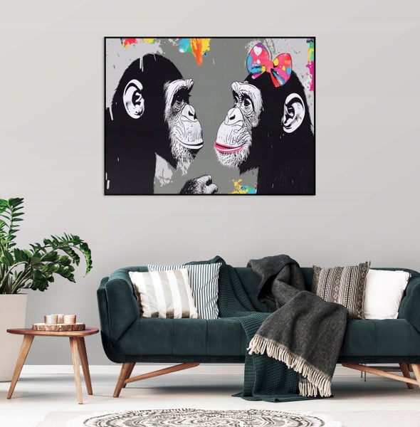 Wandbild mit zwei Schimpansen und Farbspritzern als Motiv über einem Sofa in einem modern eingerichteten Wohnzimmer.