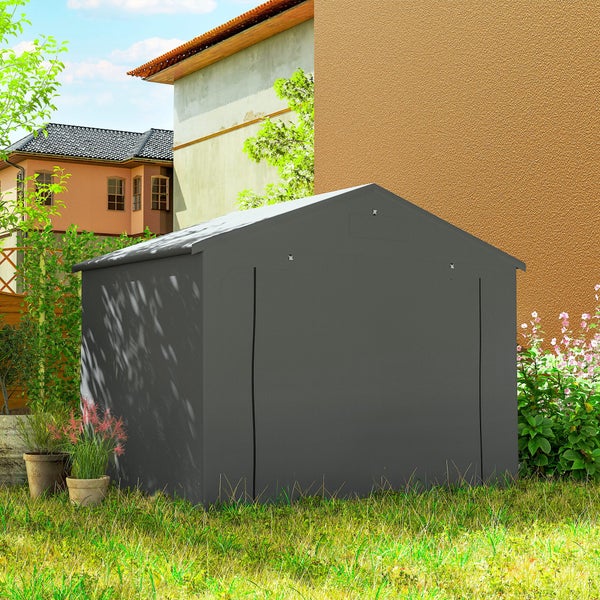 Dunkelgraues Folien-Gartenhaus mit Giebeldach, ausgestattet mit Regalen für Pflanzen sowie einer Leiter und Gartengeräten.