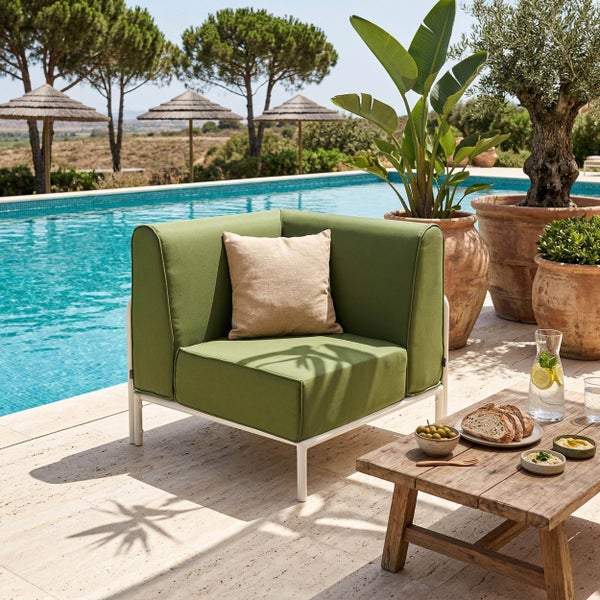 Organisierte helle Garten-Lounge-Ecke mit grünem Sessel und weißem Gestell am Pool, mit Terrakotta-Pflanzkübeln und Holztisch mit Snacks.