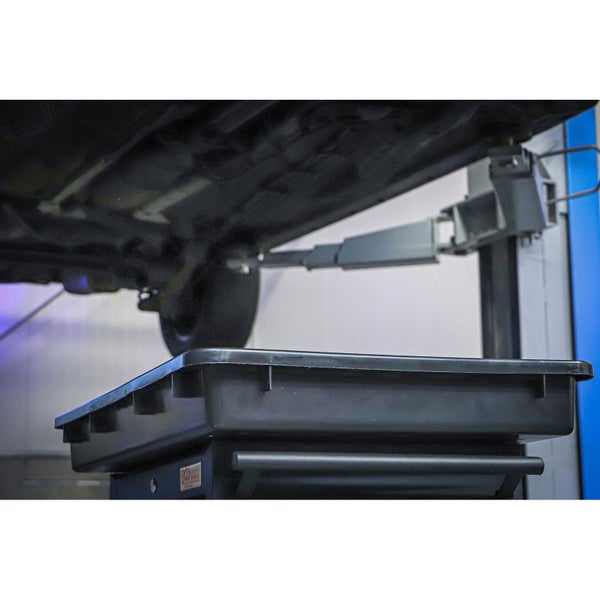 Ölauffangwanne aus Kunststoff mit Ausgießer, aus der eine dunkle Flüssigkeit fließt.