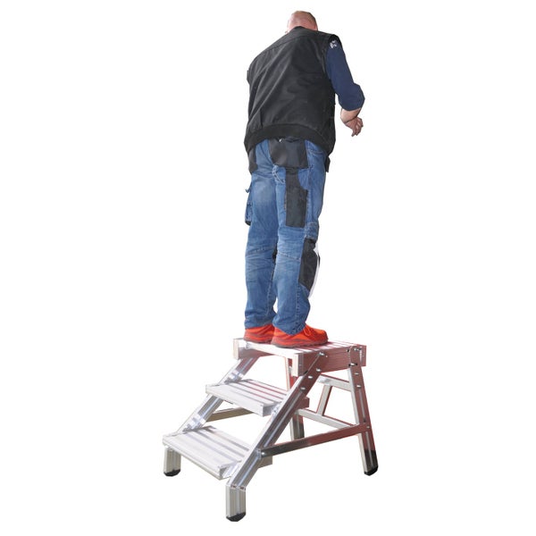 Eine Person steht auf einer robusten Aluminium Podestleiter mit drei Stufen für sicheres Arbeiten in der Höhe.