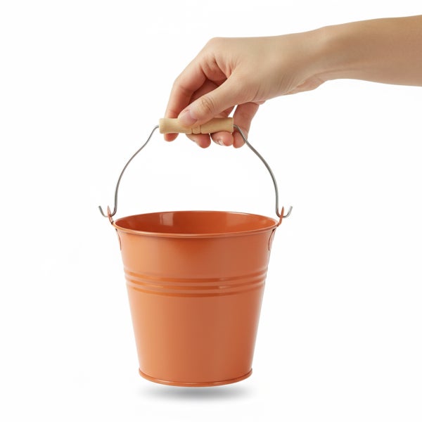 Kleiner orangefarbener Metalleimer mit Henkel und Holzgriff, gehalten von einer Hand.